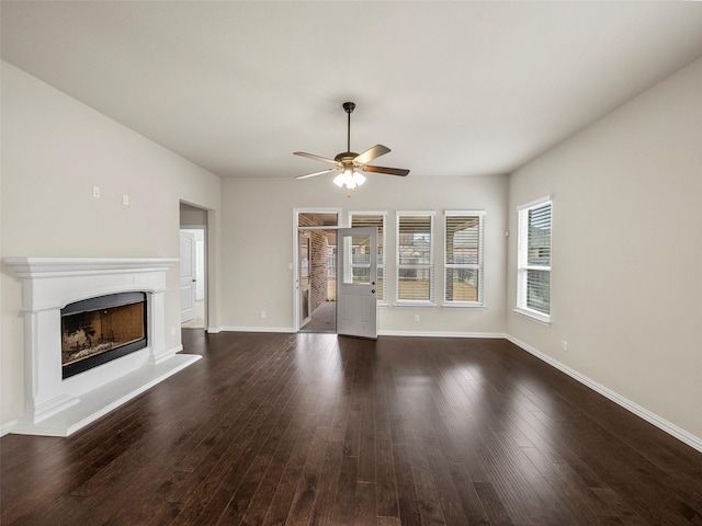 unfurnished living room featuring dark wood-type flooring and ceiling fan