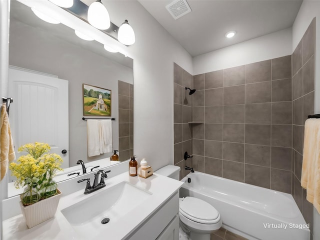 full bathroom with tiled shower / bath, vanity, and toilet