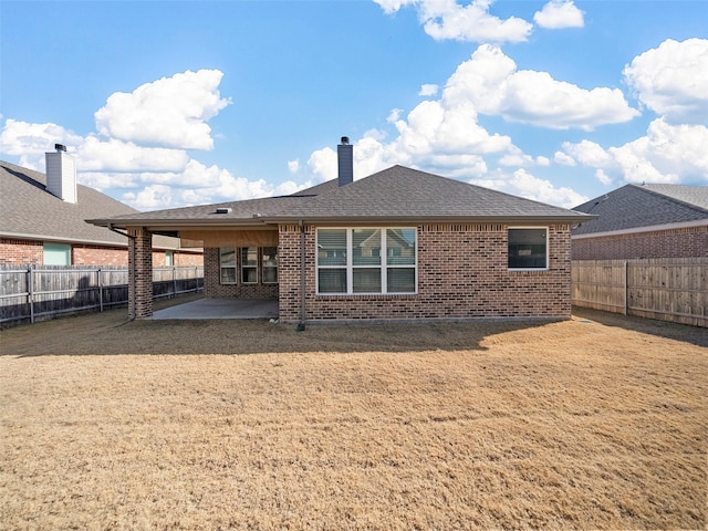 rear view of house with a patio and a lawn