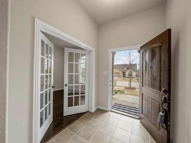 entryway with light tile patterned flooring and french doors