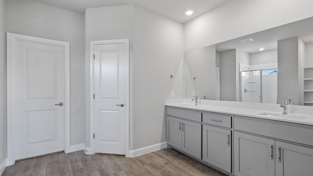 bathroom featuring a shower with door, vanity, and hardwood / wood-style floors