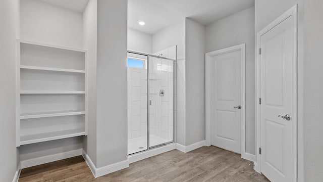 bathroom with wood-type flooring and an enclosed shower