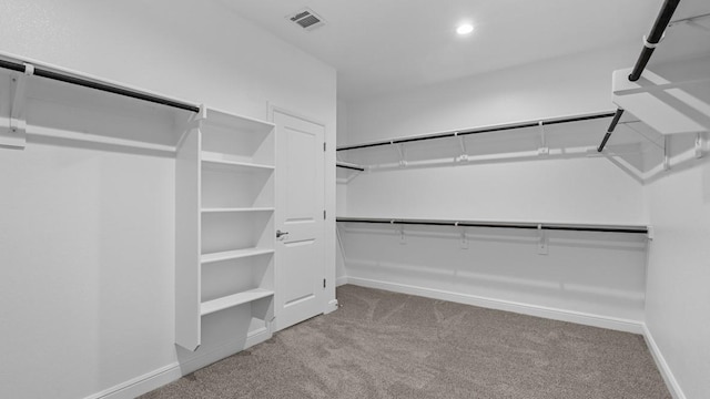 walk in closet featuring light colored carpet