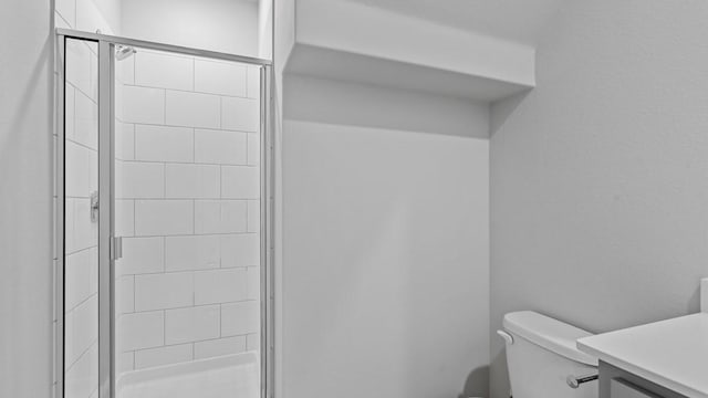 bathroom with walk in shower, vanity, and toilet