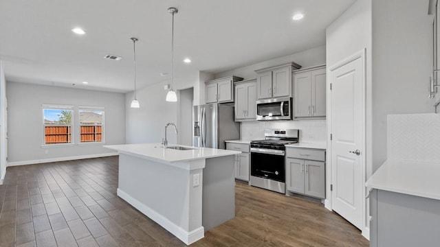 kitchen featuring gray cabinetry, sink, hanging light fixtures, and appliances with stainless steel finishes