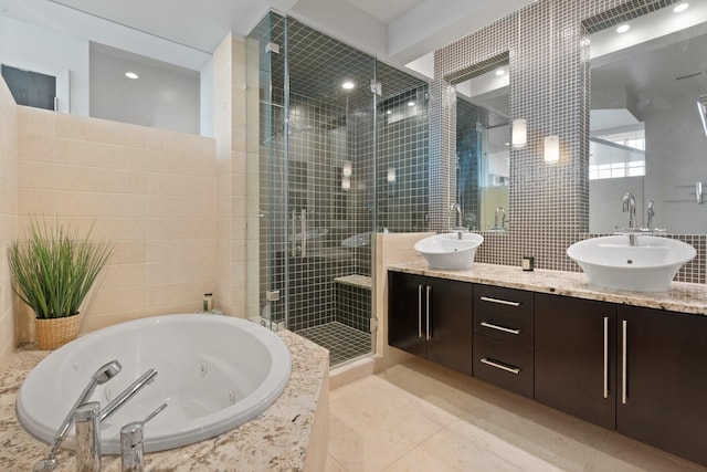 bathroom with tile walls, vanity, tile patterned flooring, and plus walk in shower