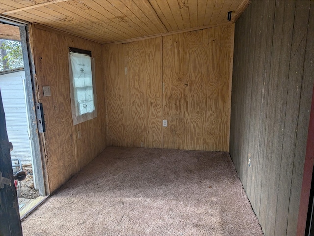 empty room featuring wood ceiling, wooden walls, and light colored carpet