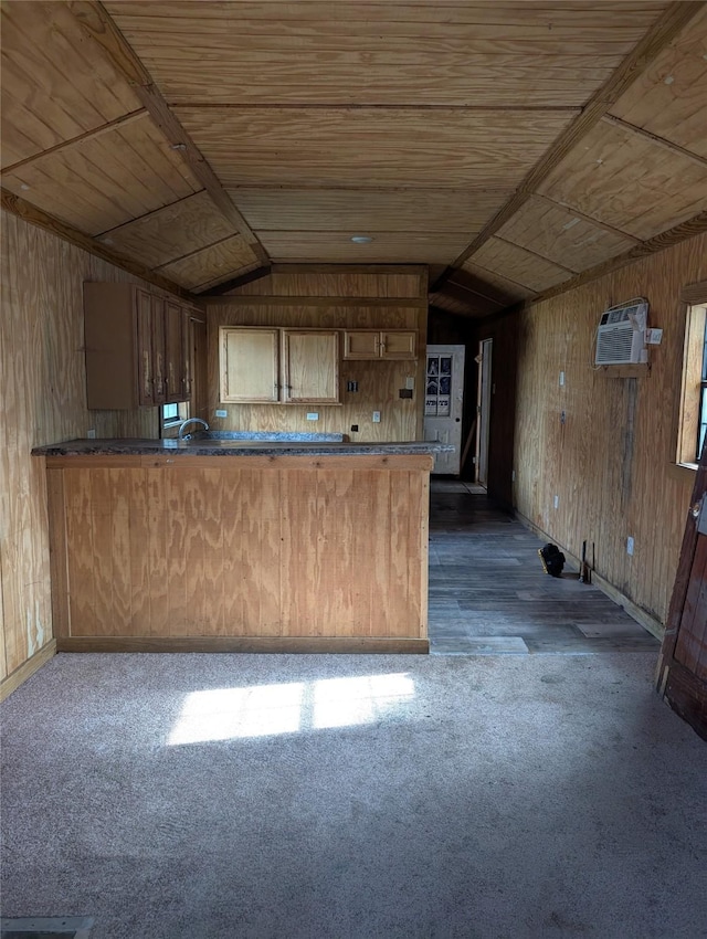 kitchen featuring wooden walls, lofted ceiling, dark colored carpet, wood ceiling, and kitchen peninsula