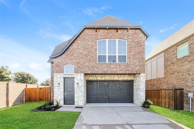 view of property with a garage and a front lawn