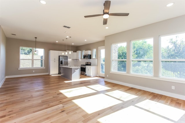 unfurnished living room with ceiling fan and light hardwood / wood-style floors