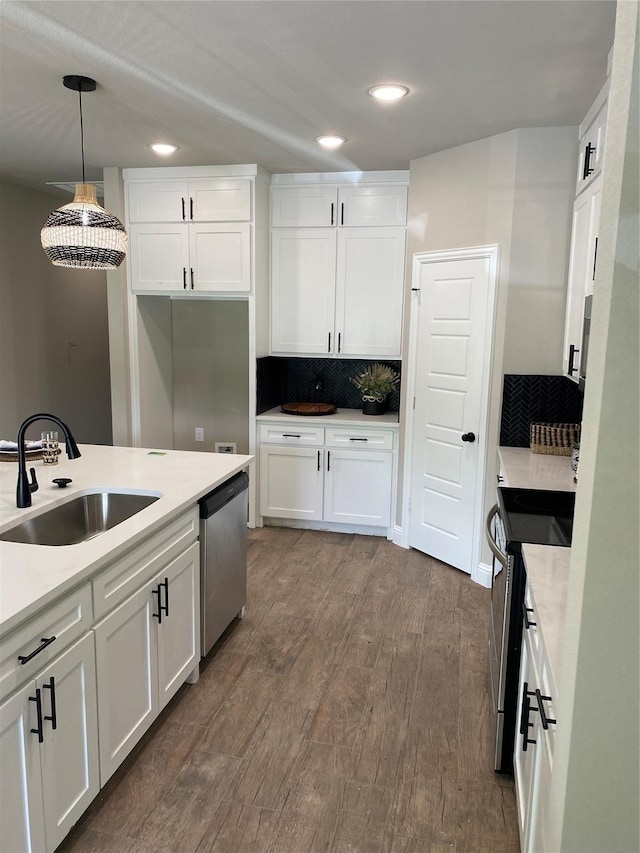 kitchen featuring pendant lighting, stainless steel appliances, sink, and white cabinets