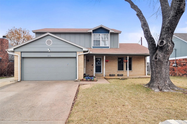 front of property with a garage, a front yard, and covered porch