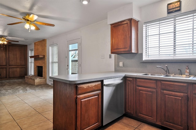 kitchen featuring sink, light tile patterned floors, dishwasher, a brick fireplace, and kitchen peninsula