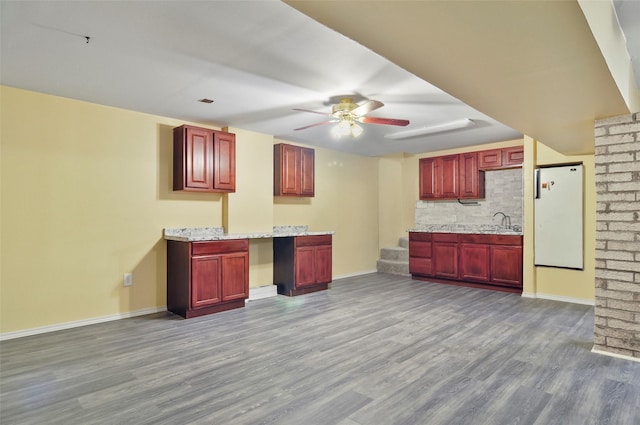 kitchen featuring hardwood / wood-style floors, sink, white refrigerator, ceiling fan, and light stone countertops