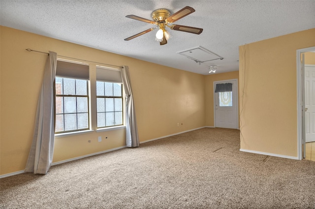 unfurnished room with ceiling fan, light colored carpet, and a textured ceiling