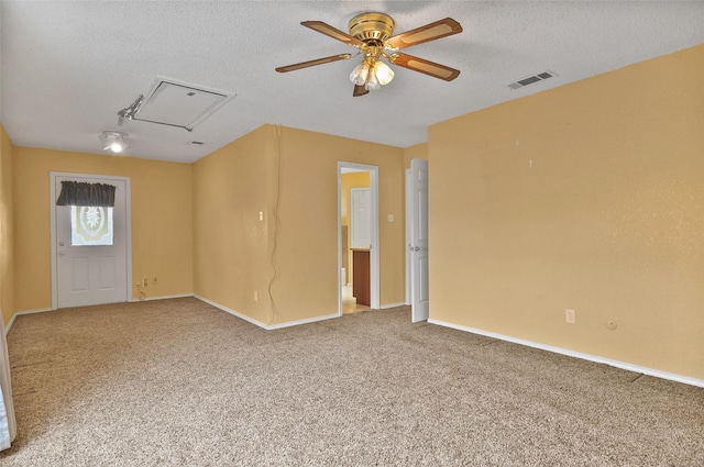 unfurnished room with ceiling fan, carpet, and a textured ceiling