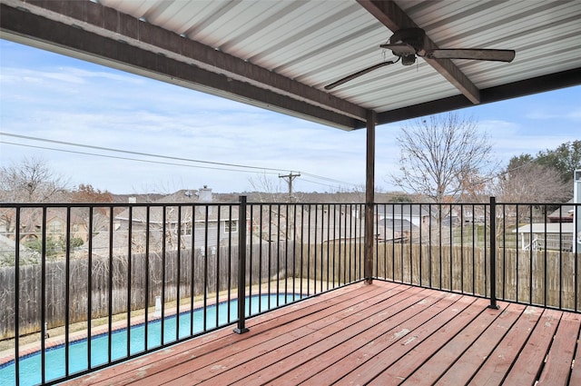 wooden terrace with a fenced in pool and ceiling fan