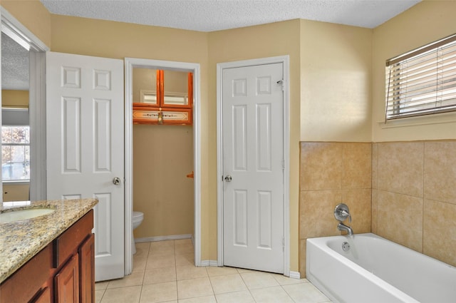 bathroom with a bathtub, tile patterned floors, a textured ceiling, and toilet