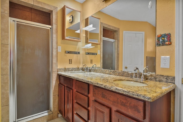 bathroom featuring a shower with door and vanity