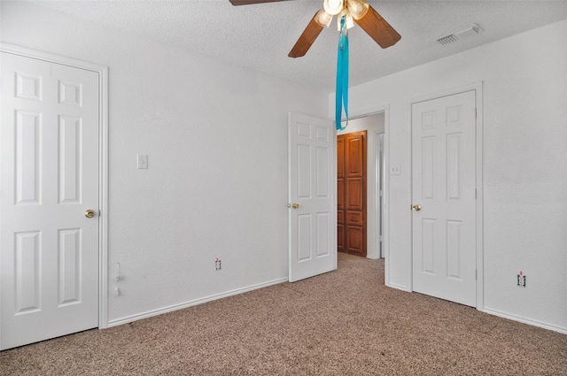 unfurnished bedroom with ceiling fan, a textured ceiling, and carpet