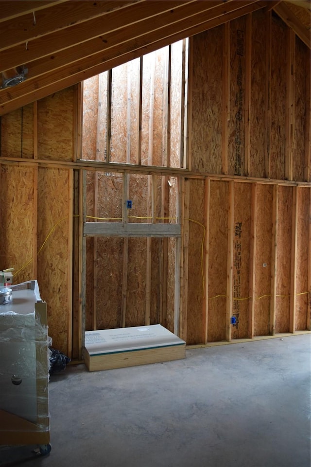 miscellaneous room with lofted ceiling and concrete flooring