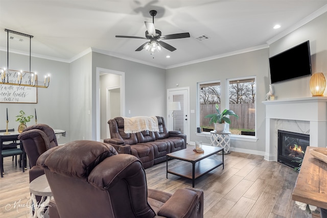 living room with ornamental molding, a premium fireplace, and light hardwood / wood-style floors