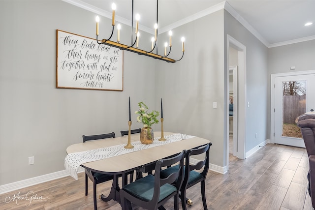 dining space with ornamental molding and hardwood / wood-style floors