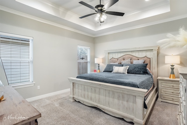 carpeted bedroom featuring a raised ceiling, crown molding, and ceiling fan