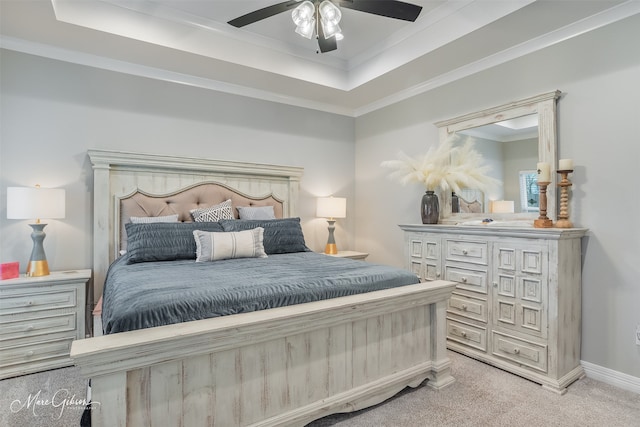 carpeted bedroom featuring ceiling fan, ornamental molding, and a raised ceiling