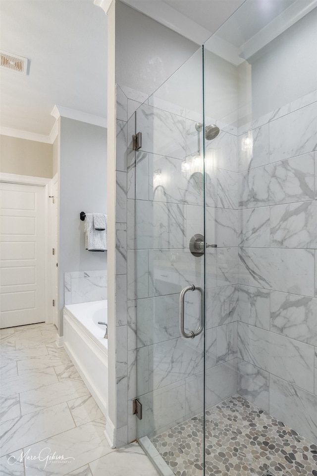 bathroom with ornamental molding and separate shower and tub