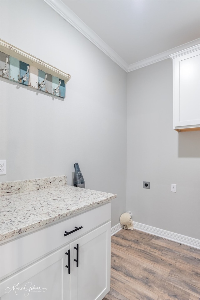 clothes washing area featuring crown molding, hookup for an electric dryer, and hardwood / wood-style flooring