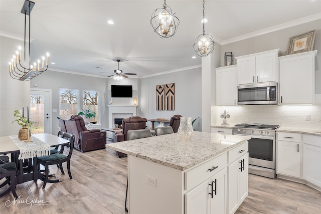 kitchen featuring white cabinetry, stainless steel appliances, a center island, and pendant lighting