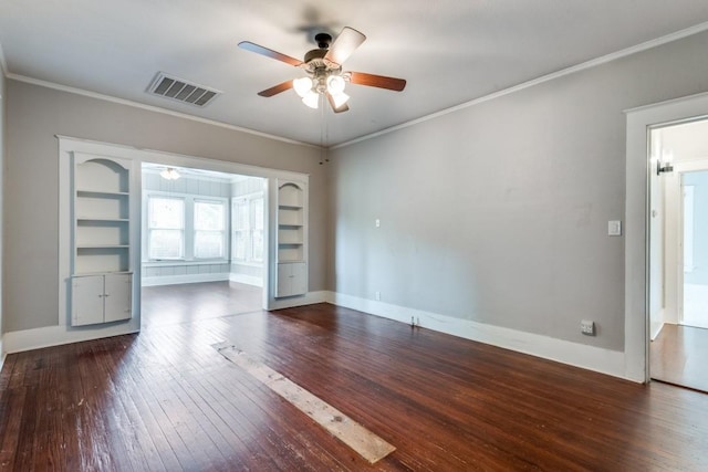 spare room featuring dark wood-type flooring, ceiling fan, ornamental molding, and built in features