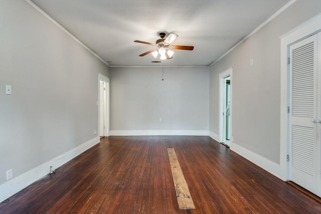 spare room featuring dark wood-type flooring, ceiling fan, and ornamental molding