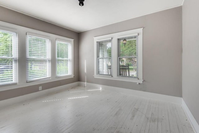 unfurnished room featuring crown molding and hardwood / wood-style floors