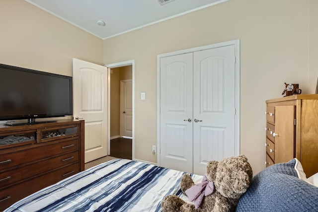 bedroom featuring crown molding and a closet