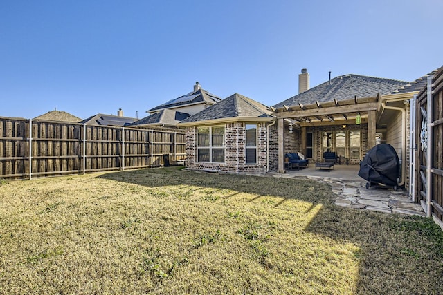 rear view of property with a yard and a patio area