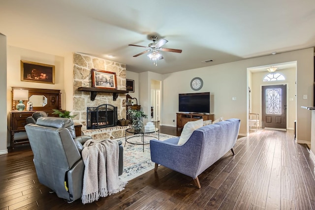 living room featuring ceiling fan, dark wood-type flooring, and a fireplace