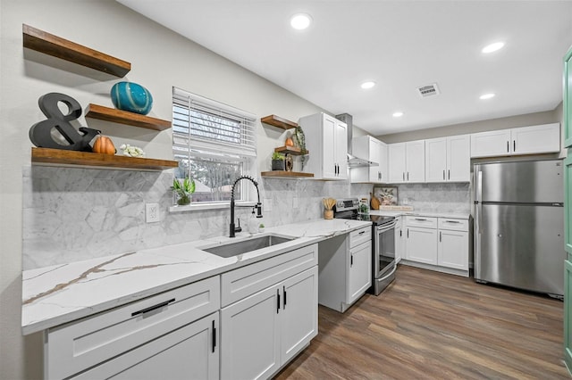 kitchen with light stone counters, stainless steel appliances, sink, and white cabinets