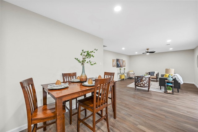 dining space with hardwood / wood-style floors and ceiling fan