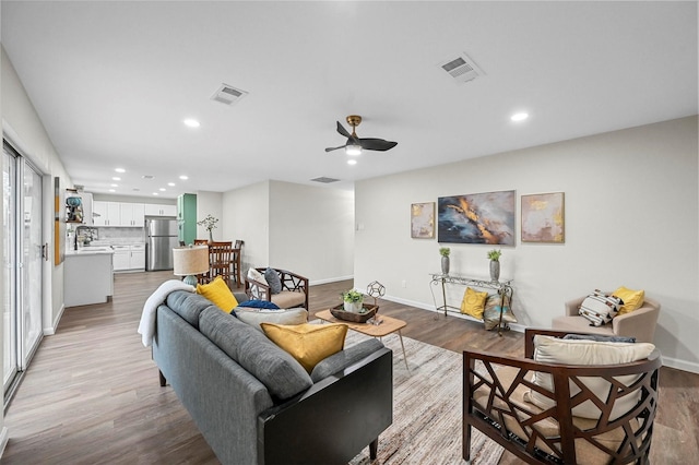 living room with ceiling fan and light hardwood / wood-style floors