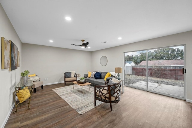 living room featuring dark hardwood / wood-style flooring and ceiling fan