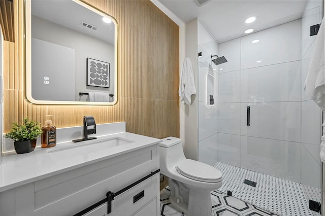 bathroom featuring vanity, toilet, and a shower with shower door