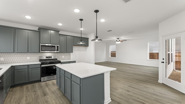 kitchen featuring gray cabinets, appliances with stainless steel finishes, a center island, and pendant lighting