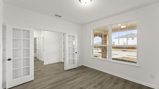 spare room featuring french doors and dark hardwood / wood-style floors