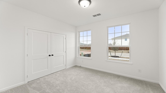 unfurnished bedroom featuring carpet floors and a closet