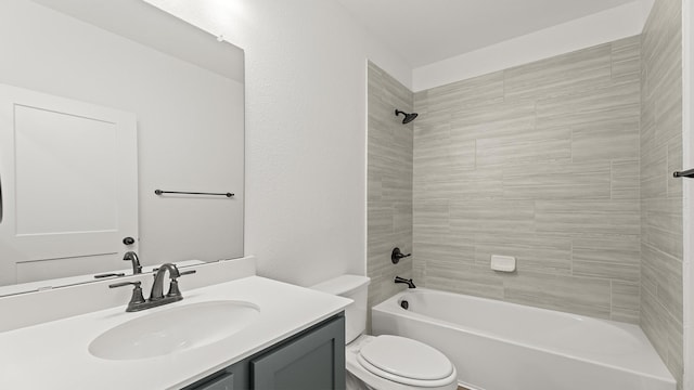 full bathroom featuring tiled shower / bath, vanity, and toilet