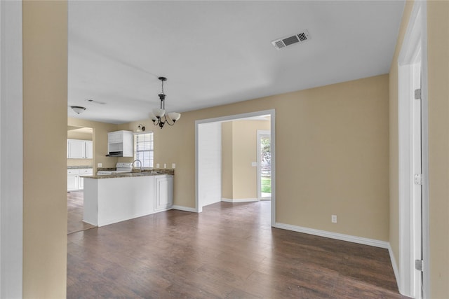 kitchen with visible vents, dark wood finished floors, open floor plan, decorative light fixtures, and white cabinetry