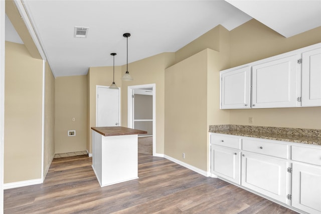 kitchen with wood finished floors, visible vents, wooden counters, and white cabinetry