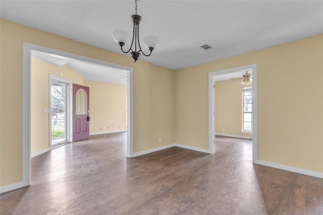 unfurnished dining area featuring dark wood-style flooring, visible vents, and baseboards